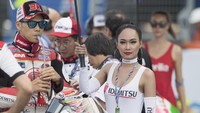 Grid girl dengan setia memayungi pebalap sebelum balapan. Dalam foto di atas, tampak seorang grid girl sedang memayungi pebalap satelit Honda Takaaki Nakagami. (Foto: Mirco Lazzari gp/Getty Images)