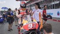 Pebalap Repsol Honda Marc Marquez tengah dipayungi oleh gadis cantik yang mengenakan seragam berwarna livery Repsol Honda. (Foto: Mirco Lazzari gp/Getty Images)