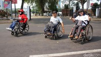 Beberapa penonton melintas menggunakan kursi roda untuk menuju venue-venue di GBK.
