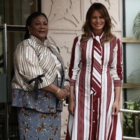 Tiba di Ghana, Melania Trump berbalut gaun bermotif garis dari Celine yang dipermanis dengan dasi. Ikut menyempurnakan gaya Melania, heels putih Manolo Blahnik. (Foto: Reuters)
