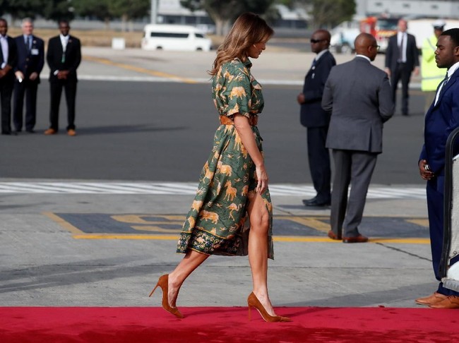 Melania lalu bertolak menuju Mesir dalam balutan shirt dress hijau bermotif binatang  nan jenaka karya Sofia Detak. Gayanya dipermanis dengan sabuk anyaman. (Foto: Reuters)