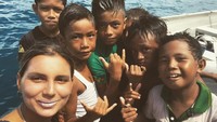 Foto: Tak hanya menunggangi ombak Mentawai, Maya juga berinteraksi dengan boca-bocah setempat. Begini keseruan mereka berpose bersama di depan kamera. (Instagram/@maya)