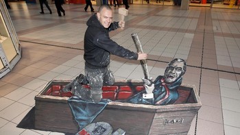 Seorang pekerja konstruksi di Liverpool, Inggris pura-pura sedang menancapkan pasak ke (gambar 3D) jantung Dracula pada Oktober 2010. (Foto: Christopher Furlong/Getty Images for Jameson)