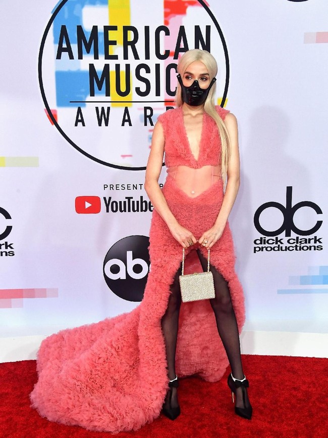 Poppy hadir dengan masker di karpet merah AMA. Bukan saja itu, pelantun Bubblebath itu mengenakan gaun bulu warna pink dan stocking yang tak matching. Foto: Getty Images