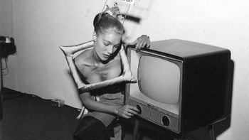 Dalam foto yang diambil dalam pameran di London tahun 1957 ini, TV yang dipamerkan tampaknya canggih pada masanya. Tengok saja penampilan si gadis peraga. (Foto: Evening Standard/Getty Images)