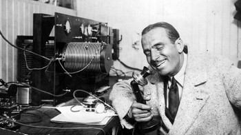 Gaya aktor Douglas Fairbanks Snr (1883 - 1939) saat memakai telepon zaman old dalam foto pada Juni 1922 ini. (Foto: General Photographic Agency/Getty Images)