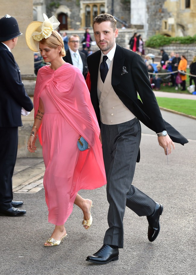 Model Inggris Pixie Geldof hadir awal untuk pernikahan Putri Eugenie. Gaun pink dengan aksen cape dari Celine mencuri atensi, yang ia padukan bersama topi ivory dan kitten heels warna serupa. Foto: Getty Images