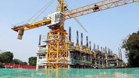 Beberapa alat berat seperti crane juga terlihat beroperasi mengangkat alat-alat bangunan dengan para pekerja yang berlalu lalang menyelesaikan tugasnya masing-masing.