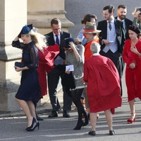 Chelsy memilih gaun biru navy dengan aksen panel transparan pada bagian lengan. Tampak di foto, Chelsy dan tamu lainnya kewalahan melawan tiupan angin yang begitu kencang di area Windsor Castle. (Foto: Getty Images)