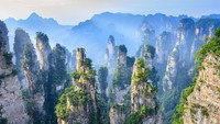 Beginilah perbukitan batu yang ada di Zhangjiajie, China. Saat cuaca berkabut, wisatawan akan terilusi pemandanganyan sehingga membuat bukit-bukit di sana terlihat melayang. Istimewa/iStock  