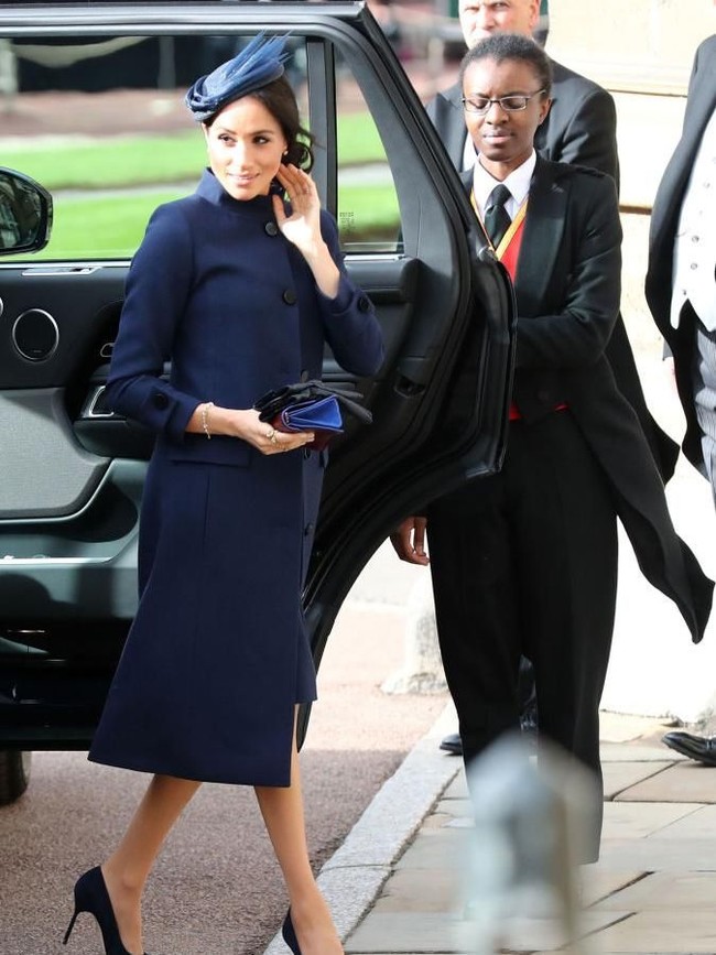 Isu kehamilan Meghan pun kembali santer saat kedatangannya di pernikahan Putri Eugenie baru-baru ini. Meghan tampil dengan gaun biru navy bersiluet coat dari Givenchy. Foto: Getty Images
