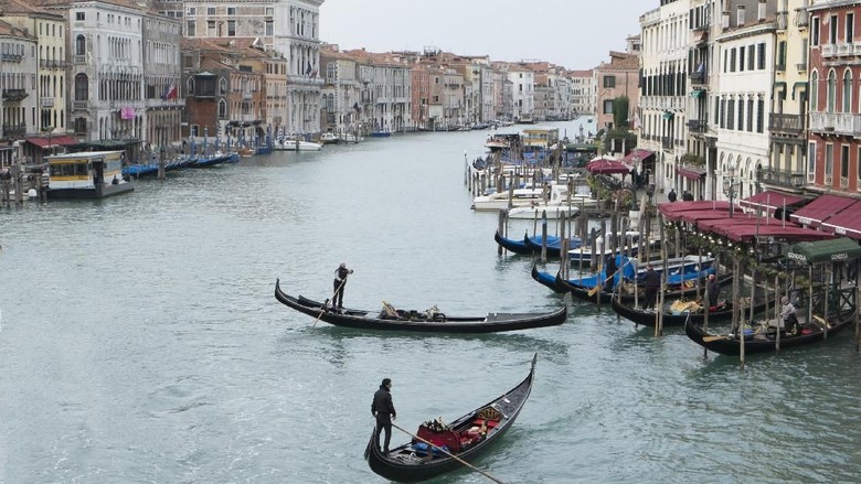 VENICE, ITALY - NOVEMBER 15:  Two gondola manouvers along an unusually empty Grand Canal around the Rialto area during the third day of strike by the transporters on November 15, 2013 in Venice, Italy.  The strike opposes the newly approved Venice council law that would impose strict controls and limits the traffic on the Grand Canal.  (Photo by Marco Secchi/Getty Images)