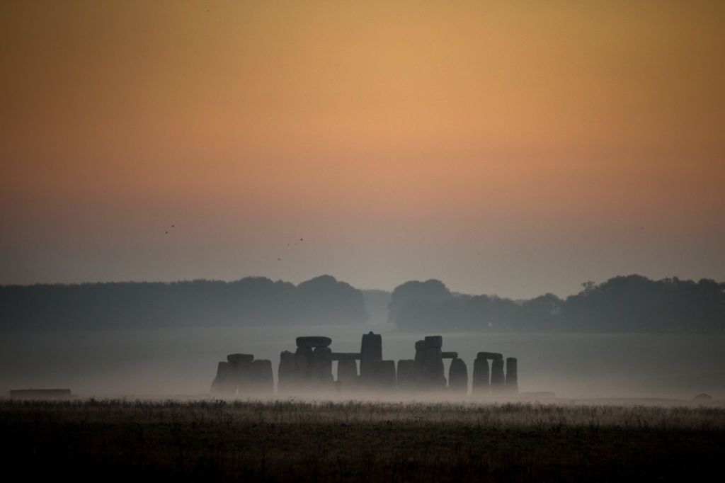 STONEHENGE, ENGLAND - OCTOBER 10:  Mist surrounds the stones at Stonehenge near Salisbury as dawn breaks on October 10, 2018 in Wiltshire, England. Many parts of the UK are experiencing temperatures almost 10C higher than average which could see the hottest October day for many years. However, the settled weather is forecast to be replaced by much more wet and windy conditions at the weekend, forcing the Met Office to issue weather warnings, as the UK braces itself for Storm CallumÂ with 80mph winds and 120mm of rain. (Photo by Matt Cardy/Getty Images)