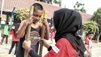 Salah seorang anak tampak sedang mencoba bermain egrang.