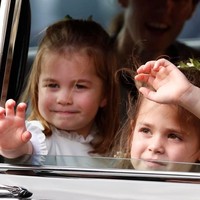 Saat masih berada di dalam mobil pun, bocah 3 tahun ini juga menyempatkan menyapa publik. Foto: Getty Images