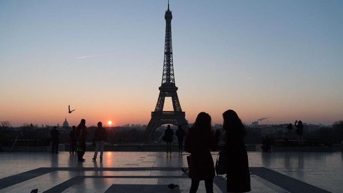 PARIS, FRANCE - JANUARY 18:  Tourists stand in front of the Eiffel tower at sunrise on January 18, 2017 in Paris, France.  (Photo by Pascal Le Segretain/Getty Images)