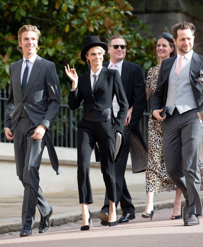 Penampilan model beralis tebal itu kontras dengan busana yang dikenakan tamu wanita lainnya di pernikahan Putri Eugenie, yakni gaun midi. Foto: Getty Images