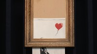 Love is in the Bin juga disebut sebagai lukisan robek karya Banksy yang kini terjual senilai Rp 356 miliar di balai lelang Sothebys London. Foto: Getty Images