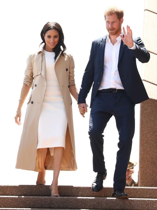Masih dari hari pertama tur, Meghan kembali membuat penampilan yang memikat dengan gaun putih Karen Gee US$ 1.800 atau Rp 27 juta, trench coat US$ 1.690 atau Rp 25 juta dan sepatu Stuart Weitzman US$ 375 atau Rp 5,6 juta. (Foto: Getty Images)