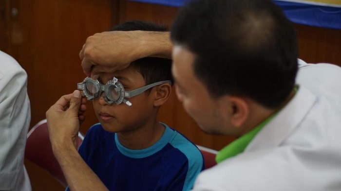 Anak-anak SD di Jakarta melakukan pemeriksaan mata gratis.