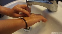 Terakhir, letakkan punggung jari pada telapak satunya, dengan jari saling mengunci. Bilas seluruh sabun dari tangan dengan bersih, keringkan dengan serbet kering atau pengering tangan. (Foto: Frieda Isyana Putri/detikHealth)