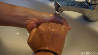 Genggam tangan kanan, lalu gosok memutar ke kanan dan ke kiri di telapak tangan kanan. (Foto: Frieda Isyana Putri/detikHealth)