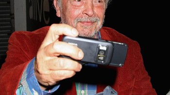 Fotografer David Bailey mengabadikan momen dengan Nokia N86, salah satu ponsel berkamera yang canggih pada masanya, pada sebuah kesempatan medio Agustus 2009. (Foto: Chris Jackson/Getty Images)