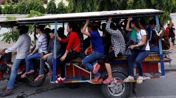 Garment workers travel back home as they leave a factory after work, on the outskirts of Phnom Penh, Cambodia, October 16, 2018. Picture taken October 16, 2018. REUTERS/Samrang Pring