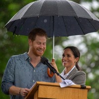 Hujan deras juga tak menghalangi Pangeran Harry untuk tetap berpidato di luar ruangan. Bukan pengawal pribadi, melainkankan Meghan yang memayungi sang suami saat berpidato. So sweet! (Foto: Getty Images)