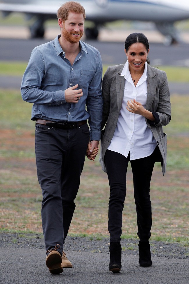 Meghan Markle turun dari pesawat tidak dengan gaun yang biasa ia kenakan ketika bertemu publik. Penampilannya kali ini lebih kasual dengan kemeja putih, celana jeans skinny dan blazer abu-abu. Foto: Dok.Getty Images
