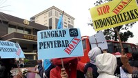 Seorang peserta demo membawa poster bertuliskan tangkap penyebar hoax.