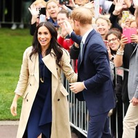 Dalam kesempatan tersebut, Meghan tampak elegan dalam balutan dress biru navy yang dibungkus trench coat coklat. (Foto: Getty Images)