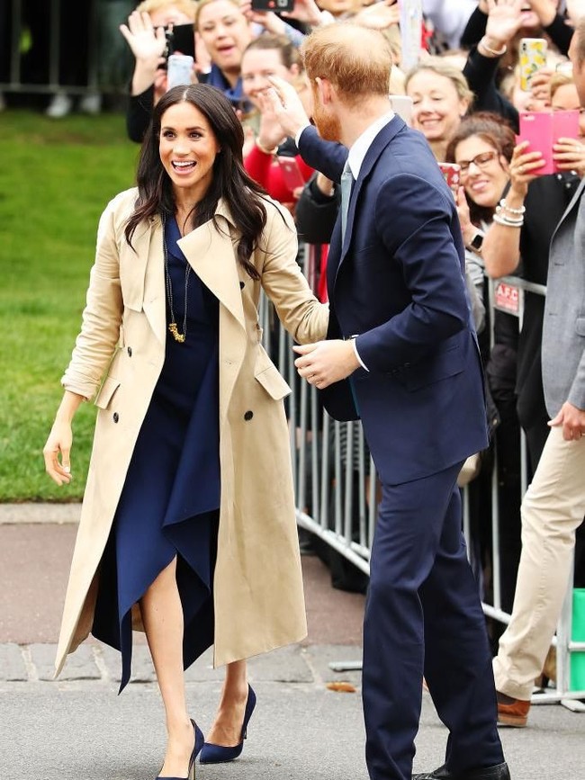 Dalam kesempatan tersebut, Meghan tampak elegan dalam balutan dress biru navy yang dibungkus trench coat coklat. (Foto: Getty Images)