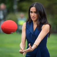 Begini aksi Meghan Markle saat bermain dengan bola rugby. Bergaun cantik tak menghalangi mantan aktris ini untuk menjajal salah satu olahraga terpopuler di Negeri Kanguru itu. (Foto: Getty Images)