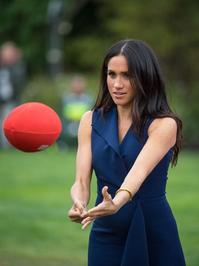 Begini aksi Meghan Markle saat bermain dengan bola rugby. Bergaun cantik tak menghalangi mantan aktris ini untuk menjajal salah satu olahraga terpopuler di Negeri Kanguru itu. (Foto: Getty Images)
