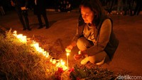 Warga memberikan bungan dan menyalakan lilin. REUTERS/Pavel Rebrov.