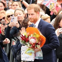 Pangeran Harry mendapat beragam buah tangan dari warga lokal yang telah menunggunya di jalanan. Ada bunga hingga boneka. (Foto: Getty Images)