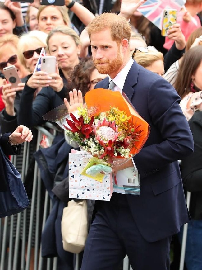 Pangeran Harry mendapat beragam buah tangan dari warga lokal yang telah menunggunya di jalanan. Ada bunga hingga boneka. (Foto: Getty Images)