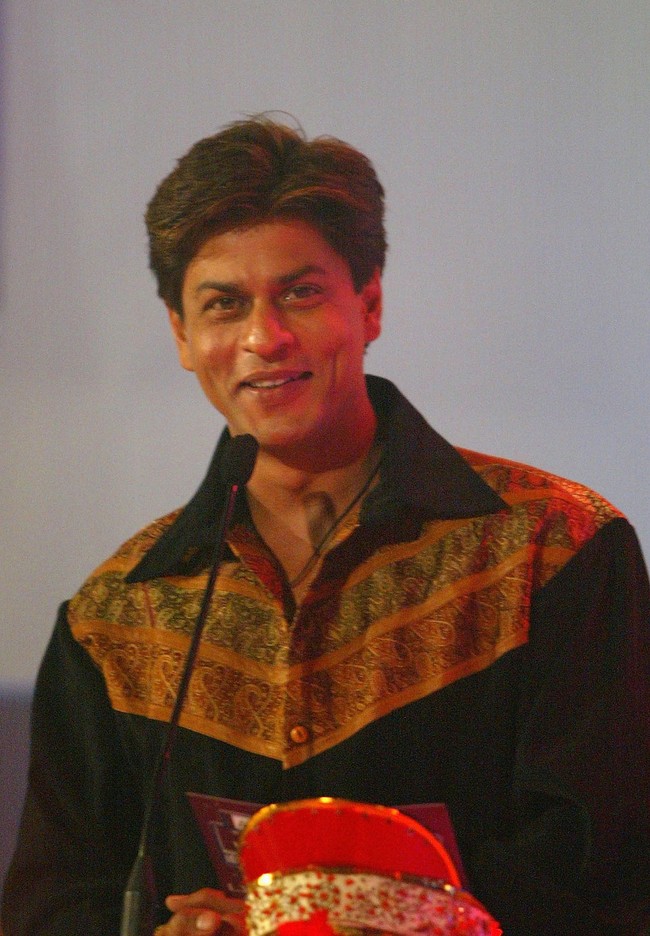 Shahrukh Khan hampir tidak pernah tampil dengan gaya rambut selain potongan ala 90-an. Kadang ditata belah pinggir, terkadang belah tengah. Tapi guntingannya selalu sama. Seperti yang ia tunjukkan pada tahun 2003 ini. Foto: Getty Images