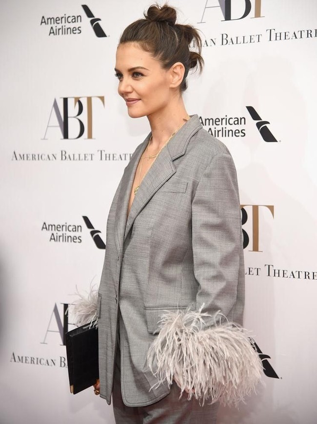 Tidak ada kemeja atau dalaman apapun, Katie hanya mengandalkan jas setelan tersebut sebagai atasan. Aksen bulu-bulu di lengan blazer dan celana menciptakan twist yang unik. (Foto: Getty Images)
