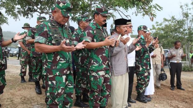 Rombongan menggelar doa bersama di lokasi pemakaman massal 