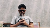 Berkunjung ke Lombok, Rian terlihat tengah duduk santai menikmati segelas es kopi. Mengenakan kaos lengan pendek, Rian juga tak lupa memakai kacamata hitam penujang penampilan. Foto: instagram Rian Ibram