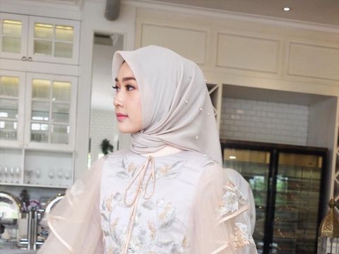 Gaun pengantin dipadukan dengan hijab segi empat paris.