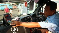 Seorang sopir menunjukkan cara menggunakan kartu One Karcis One Trip (OK Otrip).