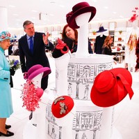 Sang Ratu tertangkap kamera tengah melihat-lihat bagian topi yang telah menjadi ikon gayanya selama puluhan tahun. Foto: Dok. Getty Images