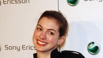 Aktris cantik Anne Hathaway memegang ponsel Sony Ericsson dengan sistem kamera tambahan yang dapat dilepas pasang. Foto: Getty Images