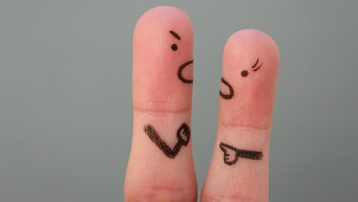 Break up, divorce and marital problems concept. Couple holding ripped pieces of paper with man and woman symbol.
