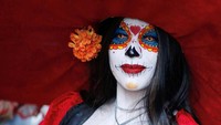 Salah seorang wanita menghias dirinya seperti seorang yang telah mati di perayaan Day of the Dead 2018 di kota Meksiko. Andres Stapff/Reuters.