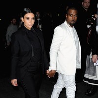 Gaya matching Kim dan Kanye dibalut setelan monokrom yang maskulin. Foto: Getty Images