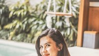 Minum es kelapa ketika berlibur dengan hamparan kolam renang biru, jadi cara Michelle habiskan waktu libur. Foto: Instagram @michellejoan